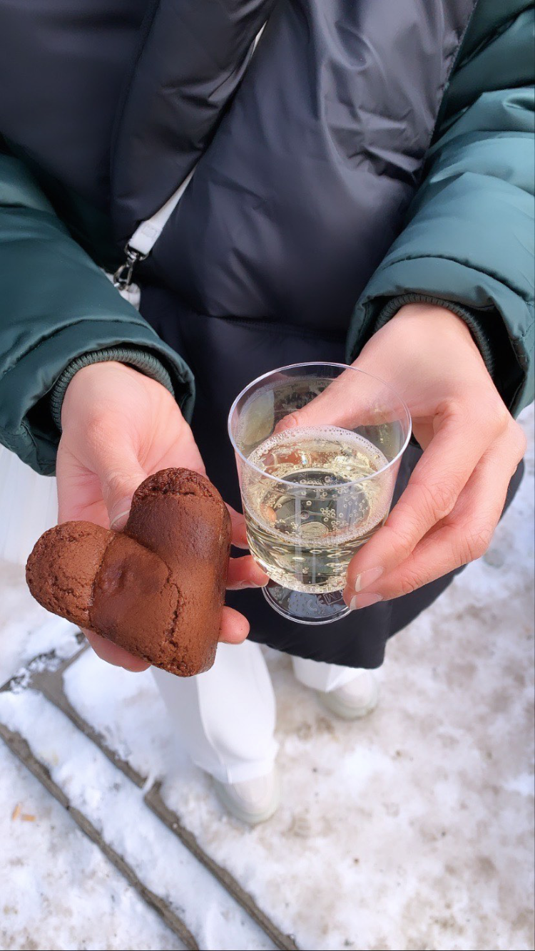 Brownie met een glaasje bubbels in de handen op een winterse dag